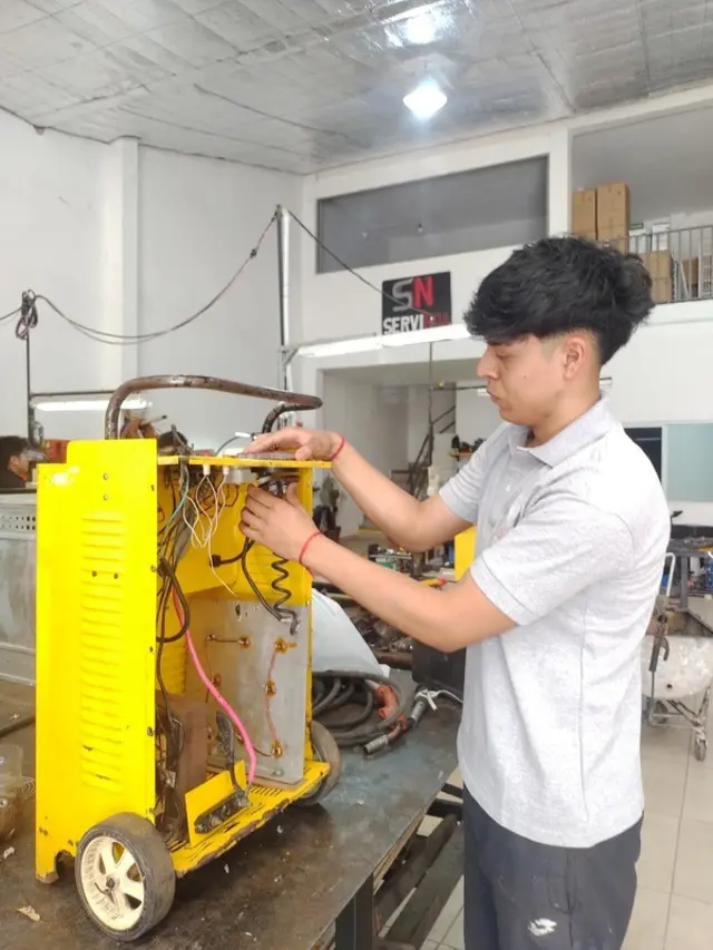 Técnico de ServiNOA reparando soldadora industrial en el taller